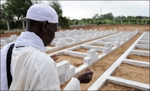Un homme prie le 26 septembre 2008 devant des tombes de victimes non identifiées du naufrage du Joola