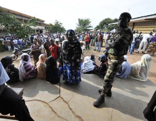 Un militaire surveille la file des électeurs qui attendent pour voter, le 31 octobre 2010 à Bouaké, en Côte d'Ivoire