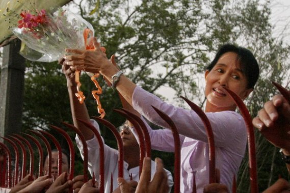 Un peu après 17h30, Aung San Suu Kyi est apparue devant les grilles de sa maison, souriant et riant. Elle a saisi une fleur qui lui avait été lancée et l'a glissée dans ses cheveux. Un peu après 17h30, Aung San Suu Kyi est apparue devant les grilles de sa maison, souriant et riant. Elle a saisi une fleur qui lui avait été lancée et l'a glissée dans ses cheveux.