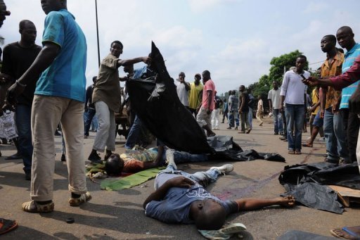 Des supporteurs d'Alassane Ouattara près des cadavres de 2 hommes, le 16 décembre 2010 à Abidjan Des supporteurs d'Alassane Ouattara près des cadavres de 2 hommes, le 16 décembre 2010 à Abidjan