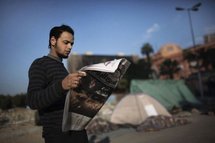 Un jeune homme lit la presse au lendemain du départ de Moubarak Un jeune homme lit la presse au lendemain du départ de Moubarak