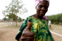 Le pouce taché d'encre, une électrice sort d'un bureau de vote. Le pouce taché d'encre, une électrice sort d'un bureau de vote.