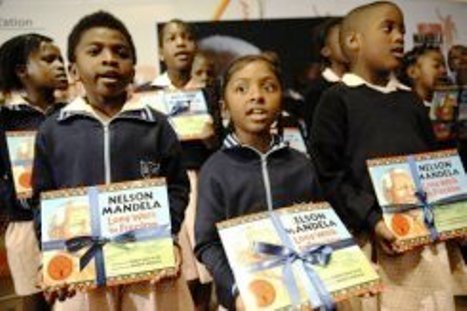 Un groupe d’écoliers tiennent un exemplaire du livre de Nelson Mandela Long walk to Freedom dans une version pour enfants, le 17 juillet 2011 à Johannesbourg Un groupe d’écoliers tiennent un exemplaire du livre de Nelson Mandela Long walk to Freedom dans une version pour enfants, le 17 juillet 2011 à Johannesbourg