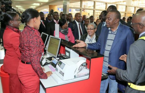 Le président kényan Uhuru Kenyatta et son épouse Margaret Kenyatta au comptoir d’enregistrement de Kenya Airways, le 7 octobre 2014 à l’aéroport de Nairobi