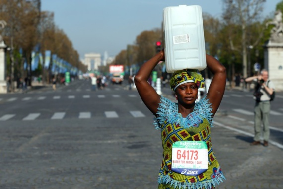 Marathon de Paris : une Gambienne au départ avec un bidon d'eau sur la tête Marathon de Paris : une Gambienne au départ avec un bidon d'eau sur la tête