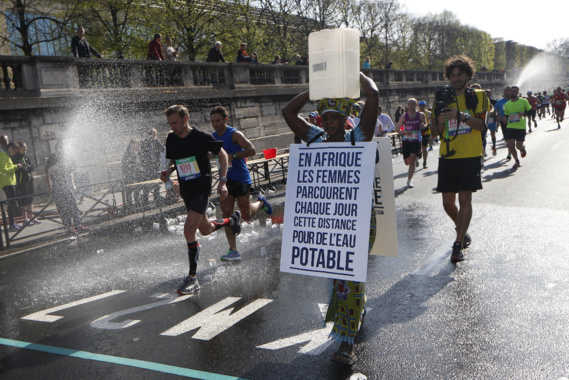 Marathon de Paris : une Gambienne au départ avec un bidon d'eau sur la tête Marathon de Paris : une Gambienne au départ avec un bidon d'eau sur la tête