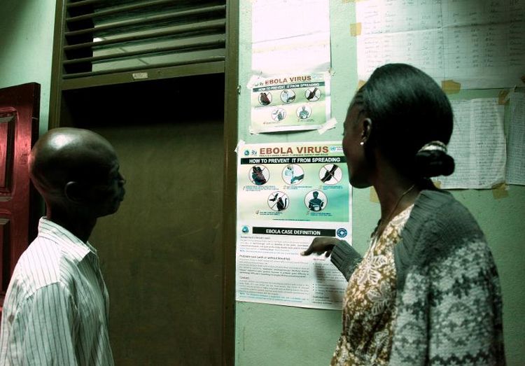 Des habitants de Monrovia au Liberia lisent une affiche d'information sur le virus Ebola le 31 juillet 2014